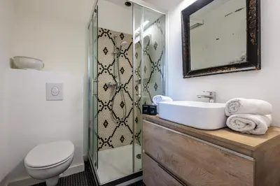 a bathroom with a sink and a toilet and a mirror at Villa du Val - Welkeys in Aix-en-Provence