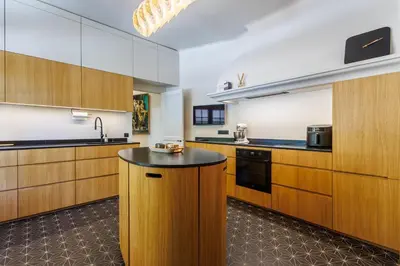 a kitchen with wooden cabinets and a black counter top at Villa du Val - Welkeys in Aix-en-Provence
