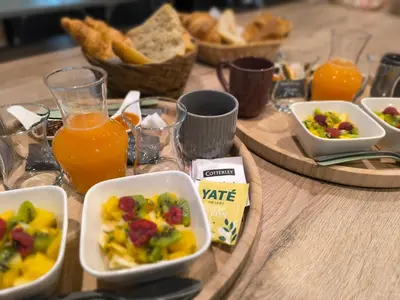 a table topped with bowls of food and orange juice at Evasion sous les pins in Aurons