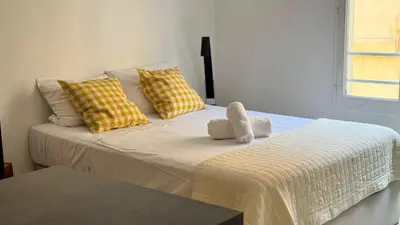 a bedroom with a bed with yellow and white pillows at Le Calisson, magnifique studio plein centre d'Aix in Aix-en-Provence