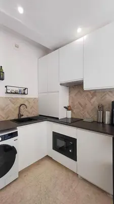 a kitchen with white cabinets and a sink and a dishwasher at Le Calisson, magnifique studio plein centre d'Aix in Aix-en-Provence