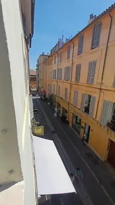 a view of a street with buildings and a white awning at Le Calisson, magnifique studio plein centre d'Aix in Aix-en-Provence