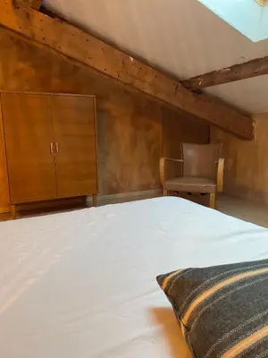 a bedroom with a bed with a wooden headboard at Rando Luberon en famille, centre d'Apt à pied in Apt