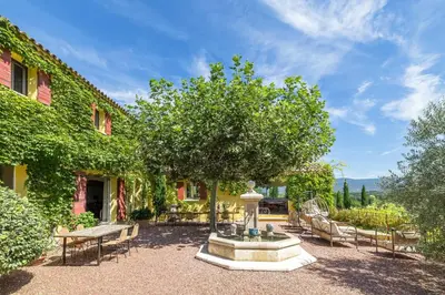 a fountain in a yard with chairs and a tree at Le Mas Jorel Luxury Pool Villa with Mountain View in Gargas
