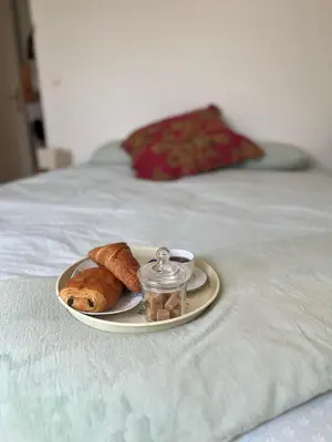 a plate of food on a bed with a wooden cabinet at Maison provençale avec jardin et piscine à Lambesc in Lambesc