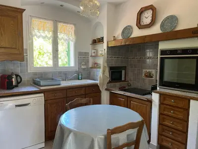 a kitchen with a table and a tv on a counter at Maison provençale avec jardin et piscine à Lambesc in Lambesc