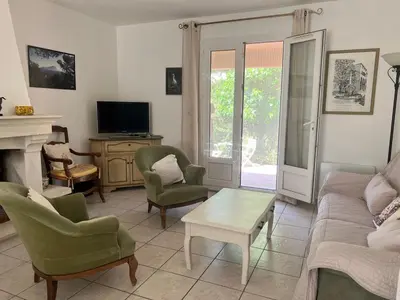 a living room with a couch and chairs and a tv at Maison provençale avec jardin et piscine à Lambesc in Lambesc