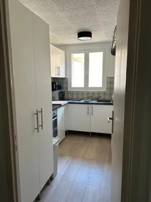 a kitchen with white cabinets and a window at Cocon douillet près du Cours Sextius in Aix-en-Provence