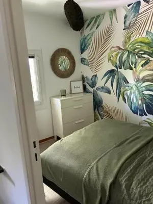 a bedroom with a green bed and plants on the wall at Cocon douillet près du Cours Sextius in Aix-en-Provence