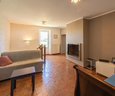 a living room with a couch and a tv at Mas Provençal au Cœur des Vignes du Luberon - 3 Chambres - Calme Absolu - Wifi in La Tour-dʼAigues