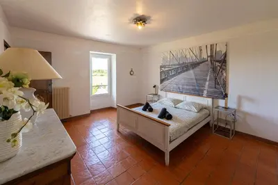 a bedroom with a bed and a painting on the wall at Mas Provençal au Cœur des Vignes du Luberon - 3 Chambres - Calme Absolu - Wifi in La Tour-dʼAigues