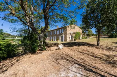 an old stone house with a tree in front of it at Mas Provençal au Cœur des Vignes du Luberon - 3 Chambres - Calme Absolu - Wifi in La Tour-dʼAigues