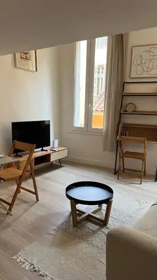 a living room with a couch and a table at Un cocon au cœur de Aix in Aix-en-Provence