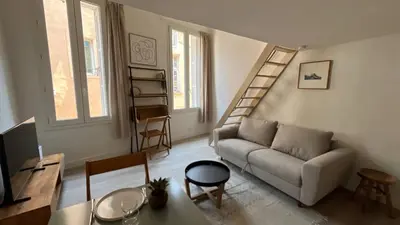 a living room with a couch and a staircase at Un cocon au cœur de Aix in Aix-en-Provence