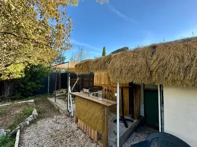 a house with a thatch roof with a counter at Villa Maguy - Piscine et jardin privée - Proche centre ville Aix en Provence - Parking - Boulodrome - Plancha in Aix-en-Provence