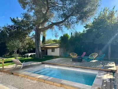 a pool with chairs and a table and a tree at Villa Maguy - Piscine et jardin privée - Proche centre ville Aix en Provence - Parking - Boulodrome - Plancha in Aix-en-Provence