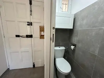 a bathroom with a toilet and a white door at Villa Maguy - Piscine et jardin privée - Proche centre ville Aix en Provence - Parking - Boulodrome - Plancha in Aix-en-Provence