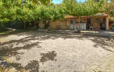 a yard with a dirt ground in front of a house at Gîte Avec Piscine in La Tour-dʼAigues