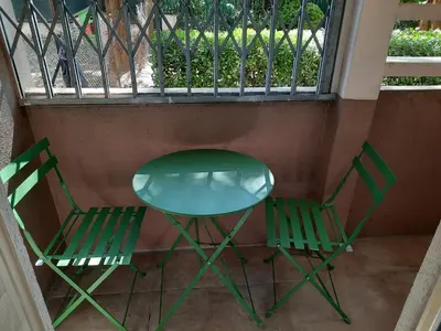 two green chairs and a table on a balcony at Appartement Le Cézanne in Aix-en-Provence