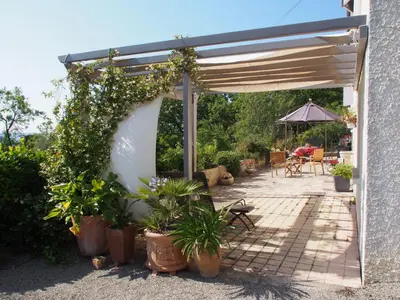a pergola with potted plants on a patio at Une Heure Bleue in Manosque