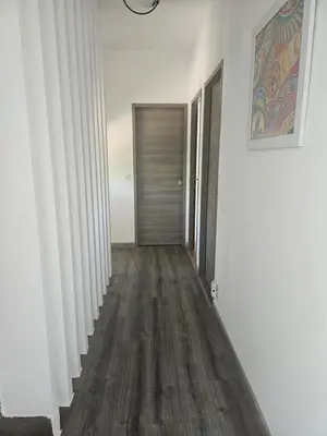 a hallway with white walls and wood floors at Villa sous les pins in Ventabren