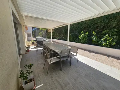 a patio with a table and chairs on it at Villa sous les pins in Ventabren