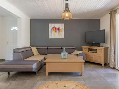 a living room with a couch and a tv at Villa A l'Ombre du Soleil by Interhome in Monteux