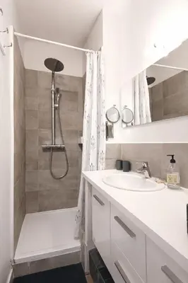 a white bathroom with a shower and a sink at T2 Centre historique d'Aix-en-Provence in Aix-en-Provence