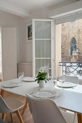 a white dining room with a white table and chairs at T2 Centre historique d'Aix-en-Provence in Aix-en-Provence