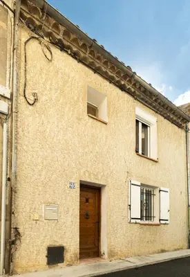 a large brick building with a wooden door at Maison de village chaleureuse in Sainte-Tulle