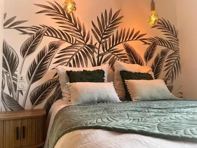 a bedroom with a bed with a large leafy wall at Le Moulin in Aix-en-Provence