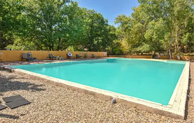 a swimming pool with blue water in a yard at Maison Avec Piscine in Villars