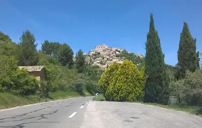 an empty road with a building on top of a hill at Maison Avec Piscine in Villars
