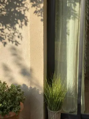 a window with two potted plants and a curtain at Mas Coeur Provence Calme Beauté Grand Parc in Pernes-les-Fontaines