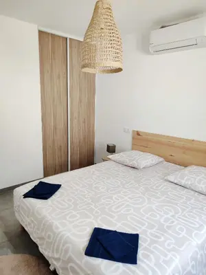 a bedroom with a bed with blue pillows on it at Le Picholine in Mazan