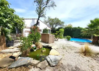 a garden with a pond in front of a house at Pasca'land in Velaux