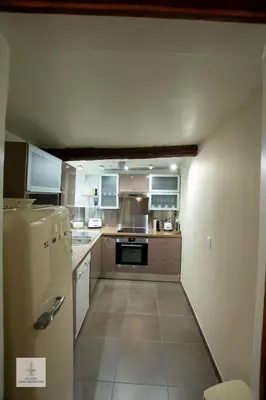 a kitchen with white cabinets and a refrigerator at Maison des Chaudronniers in Aix-en-Provence