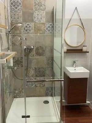 a shower with a glass door next to a sink at Studio climatisé au centre du village in Saint-Michel-lʼObservatoire