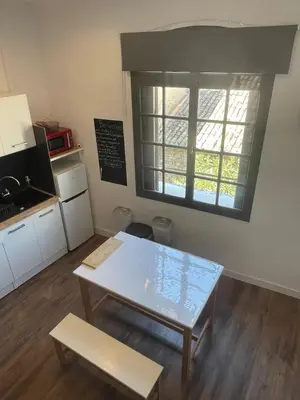 a small kitchen with a table and a window at Studio climatisé au centre du village in Saint-Michel-lʼObservatoire