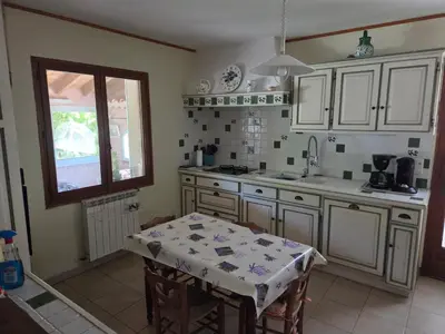 a kitchen with white cabinets and a table in it at Villa avec piscine privée in Alleins