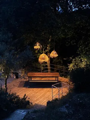 a wooden bench sitting on a wooden deck with lights at Lourmarin Family Country House in Cadenet
