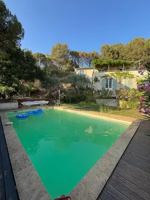 a swimming pool with green water in a yard at Lourmarin Family Country House in Cadenet