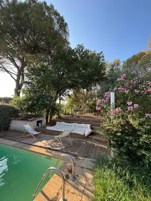 a swimming pool with chairs and trees and flowers at Lourmarin Family Country House in Cadenet