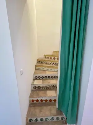 a set of stairs with a green curtain at La Régalade in Le Puy-Sainte-Réparade