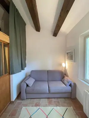 a living room with a blue couch in a room at La Régalade in Le Puy-Sainte-Réparade