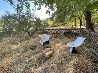 two white chairs sitting in the grass next to a fence at La Régalade in Le Puy-Sainte-Réparade