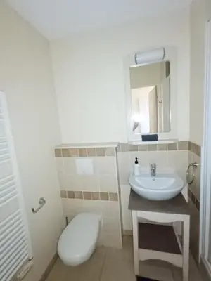 a white bathroom with a toilet and a sink at Domaine de Pont royal in Mallemort