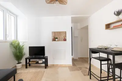 a living room with a television and a table at Suite Lueur de Sable - Hypercentre - WiFi in Apt