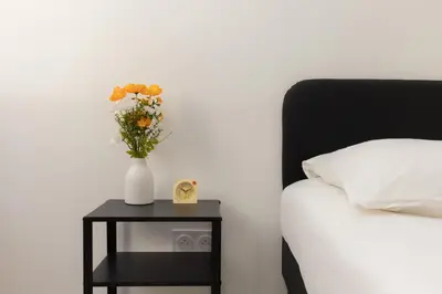 a vase of flowers on a table next to a bed at Suite Lueur de Sable - Hypercentre - WiFi in Apt