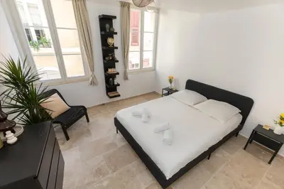 a living room with a bed and a chair at Suite Lueur de Sable - Hypercentre - WiFi in Apt